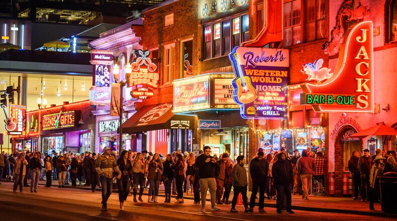 People make their way up and down Broadway in downtown Nashville, Tenn., Feb. 17, 2023. Nashville today combines tradition and evolution, where you can visit old-school restaurants and slick cocktail temples, stroll ravishing gardens and trace the impact of Black music at a new interactive museum. (William DeShazer/The New York Times)