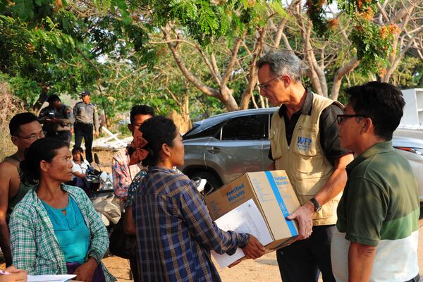 Michael Dunford, World Food Programme Country Director in Myanmar, hands aid boxes to earthquake survivors at Ottara Thiri Hospital in Naypyitaw, Myanmar, Sunday, March 30, 2025. (Diego Fernandez/World Food Programme via AP)