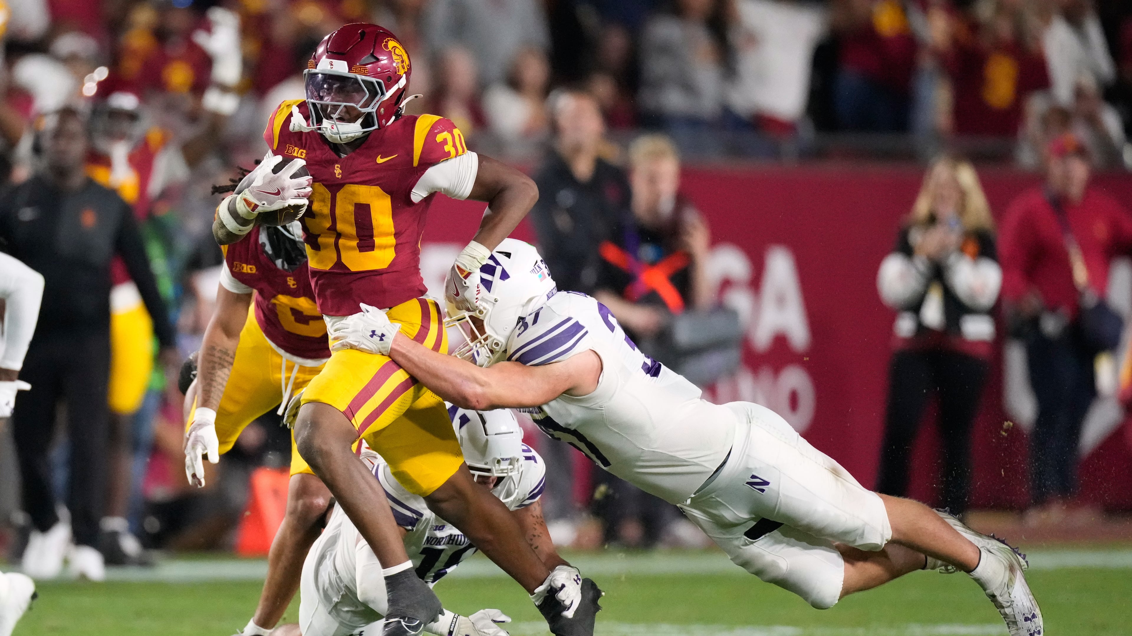 Southern California running back King Miller, left, breaks a tackle by Northwestern linebacker Mac Uihlein during the first half of an NCAA college football game Friday, Nov. 7, 2025, in Los Angeles. (AP Photo/Mark J. Terrill)