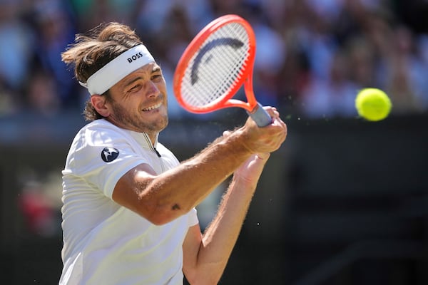 Taylor Fritz of the U.S. returns to Spain's Carlos Alcaraz in a men's singles semifinal at the Wimbledon Tennis Championships in London, Friday, July 11, 2025. (AP Photo/Kin Cheung)