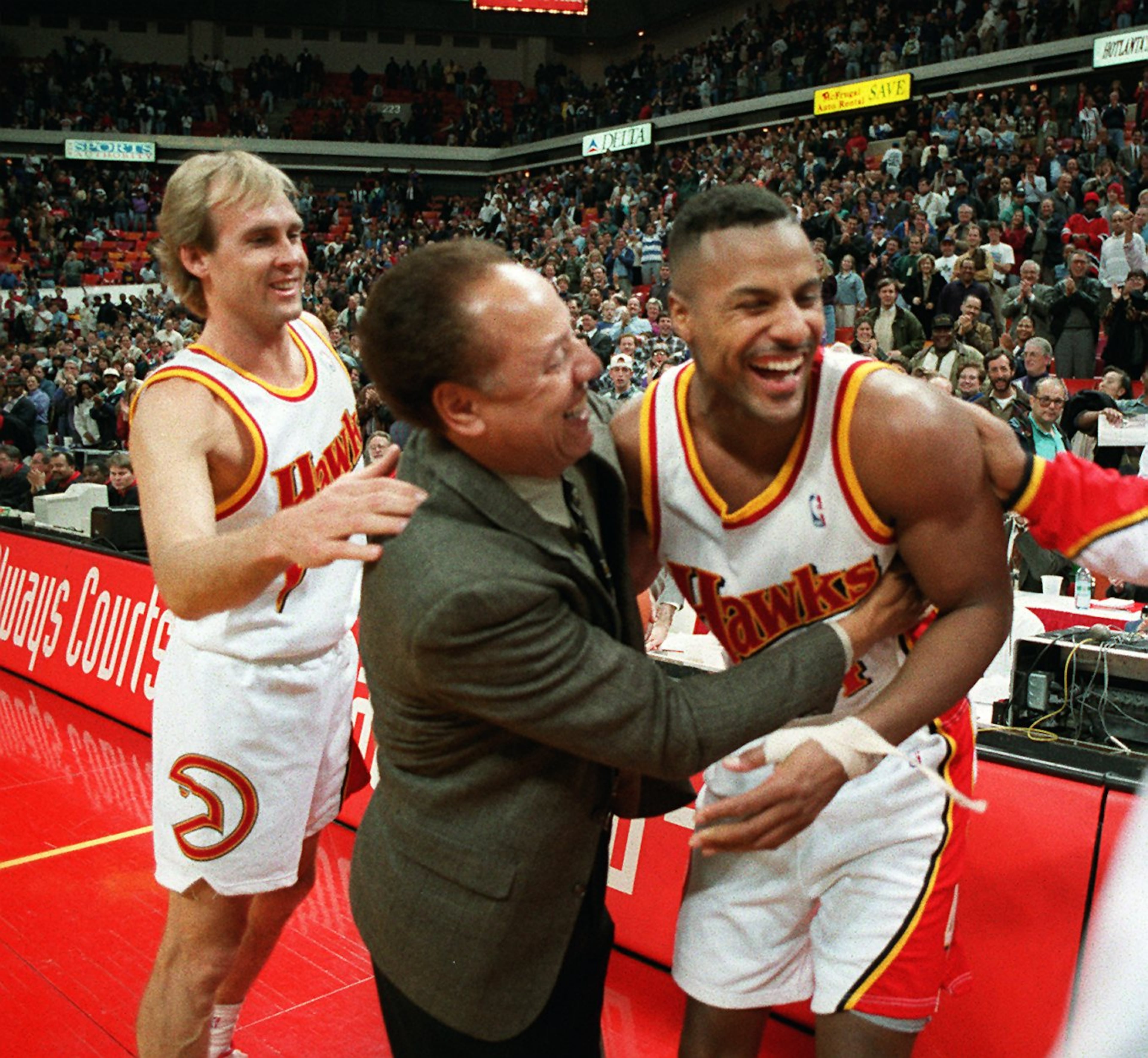 Hawks players Craig Ehlo and Steve Smith congratulate coach Lenny Wilkens after the coach tied the NBA record for career wins. AJC file photo