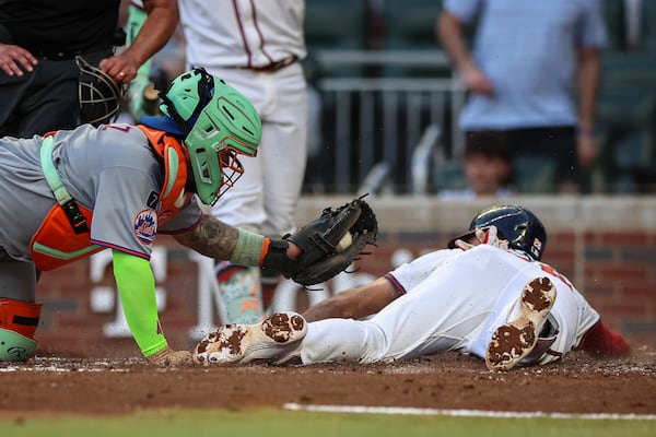 Atlanta Braves' Matt Olson, right, slides home ahead of a tag from New York Mets catcher Francisco Alvarez, left, in the fourth inning of a baseball game, Thursday, June 19, 2025, in Atlanta. (AP Photo/Colin Hubbard)
