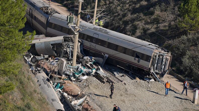 Guardia Civil officers collect evidence next to the wreckage of train cars involved in a collision in Adamuz, southern Spain, Tuesday, Jan. 20, 2026. (AP Photo/Manu Fernandez)
