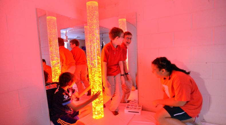 Sixth-grade students (from left) Aidan Hurtado, Jason Heath and Gabriela Coty, all 11, use the calm room with relaxing chairs, a music system and a multicolored bubble light at Tapestry Public Charter School.