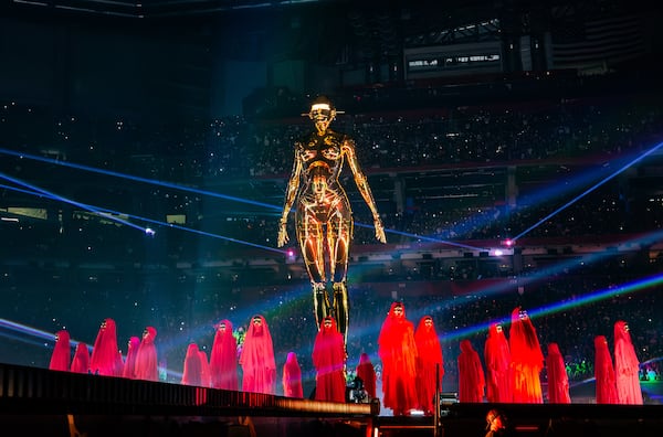 A giant, curvy and metallic statuette encapsulates the middle of Mercedes-Benz Stadium as dozens of dancers dressed in red robes perform with The Weeknd during his Atlanta show on Thursday, Aug. 21, 2025. (Ryan Fleisher for the AJC)