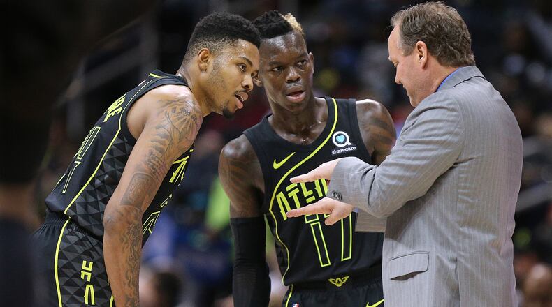 Hawks coach Mike Budenholzer, here with Kent Bazemore and Dennis Schroder, has attempted to keep his players focused on the day-to-day process and not all of the losses that the team has had this season.