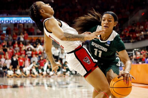 Michigan State's Jocelyn Tate (11) charges into North Carolina State's Aziaha James (10) during the first half in the second round of the NCAA college basketball tournament in Raleigh, N.C., Monday, March 24, 2025. (AP Photo/Karl DeBlaker)