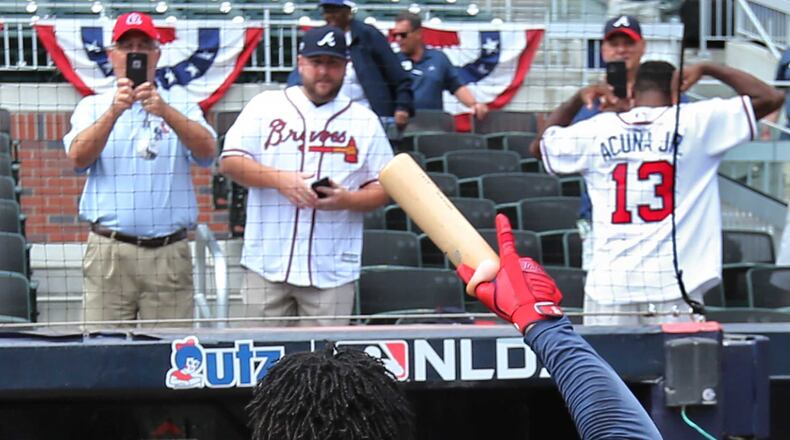 Braves' Ronald Acuna Jr. recognizes cheering Braves fans, one wearing his jersey, in 2019.