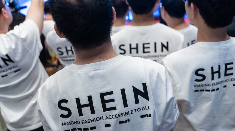 A logo of fast-fashion retailer Shein is seen on the t-shirt at the listing ceremony in Hong Kong, Tuesday, Sept. 1, 2026. (AP Photo/Chan Long Hei)