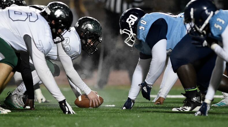 North Hall High School football players, left, and Cedar Grove High School football players can see their breath before a play, Friday, Nov. 16, 2018, in Decatur, Georgia.Temperatures were in the 40s towards the end of the game. (Annie Rice/AJC)