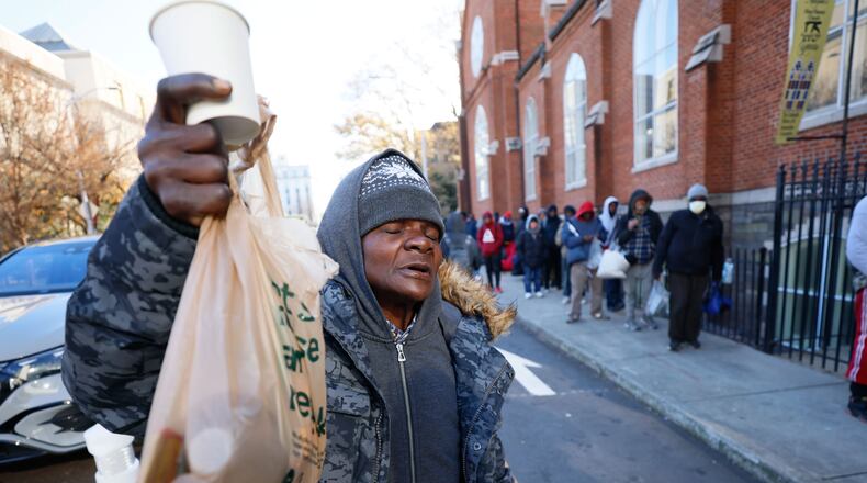 Homeless Angela Fairman reacts with gratitude after receiving a cup of coffee and a bag of sandwiches outside the Catholic Shrine of the Immaculate Conception on Thursday, Dec. 14, 2023.
Miguel Martinez /miguel.martinezjimenez@ajc.com