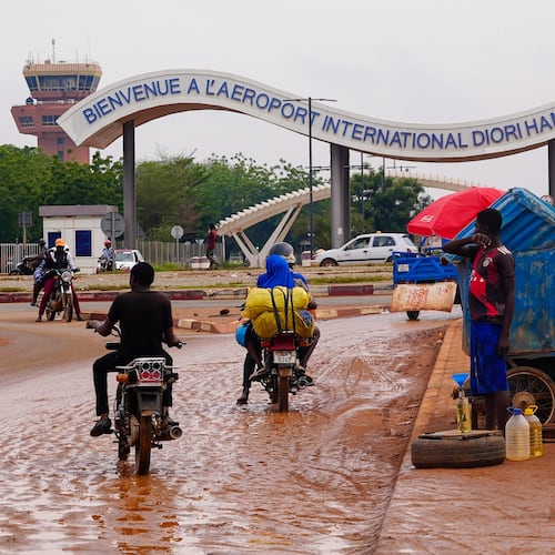 FILE - Motorcyclists ride by the entrance of the airport in Niamey, Niger, Aug. 8, 2023. (AP Photo/Sam Mednick, File)
