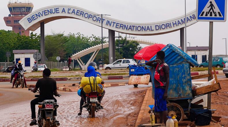 FILE - Motorcyclists ride by the entrance of the airport in Niamey, Niger, Aug. 8, 2023. (AP Photo/Sam Mednick, File)