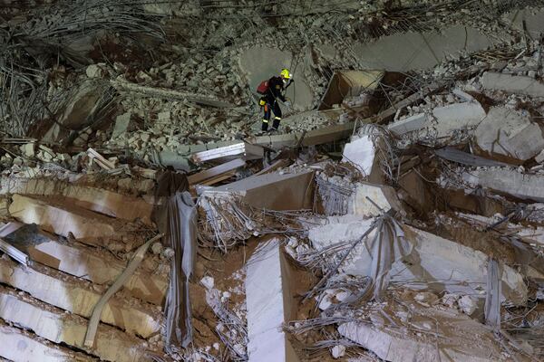 A rescuer looks for survivors at the site of an under-construction high-rise building that collapsed after an earthquake in Bangkok, Thailand, Monday, March, 31, 2025. (AP Photo/Wason Wanichakorn)