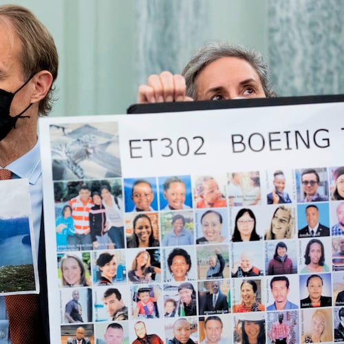 FILE - Michael Stumo, holding a photo of his daughter Samya Stumo, and his wife Nadia Milleron, sit behind FAA Administrator Steve Dickson during a Senate Committee on Commerce, Science, and Transportation hearing on the implementation of aviation safety reform at the U.S. Capitol in Washington, Nov. 3, 2021. (AP Photo/Amanda Andrade-Rhoades, File)