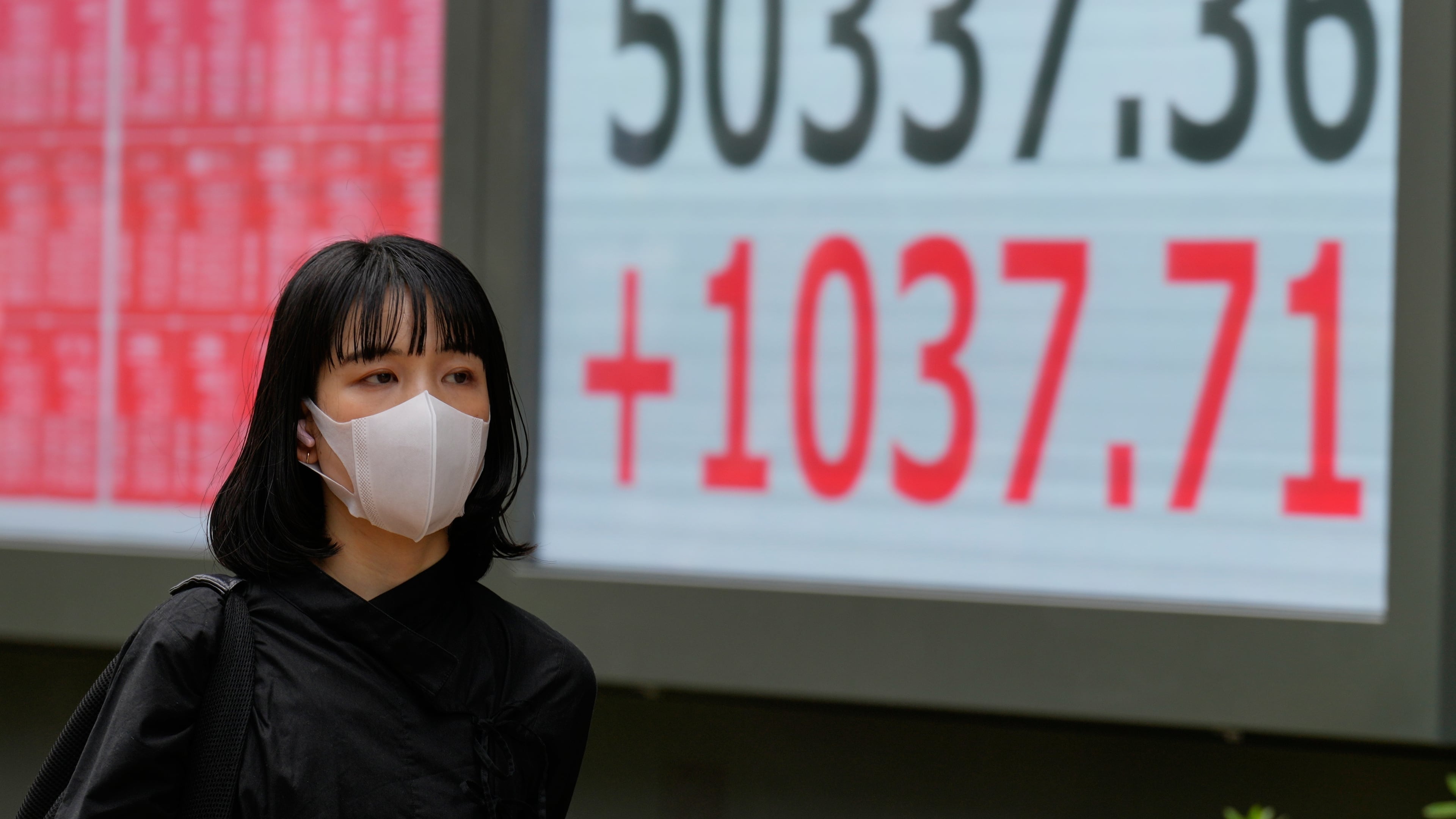 A person walks in front of an electronic stock board showing Japan's Nikkei index at a securities firm Monday, Oct. 27, 2025, in Tokyo. (AP Photo/Eugene Hoshiko)