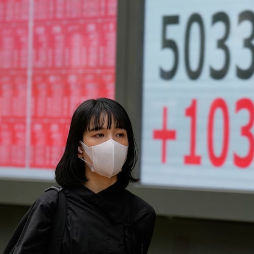 A person walks in front of an electronic stock board showing Japan's Nikkei index at a securities firm Monday, Oct. 27, 2025, in Tokyo. (AP Photo/Eugene Hoshiko)