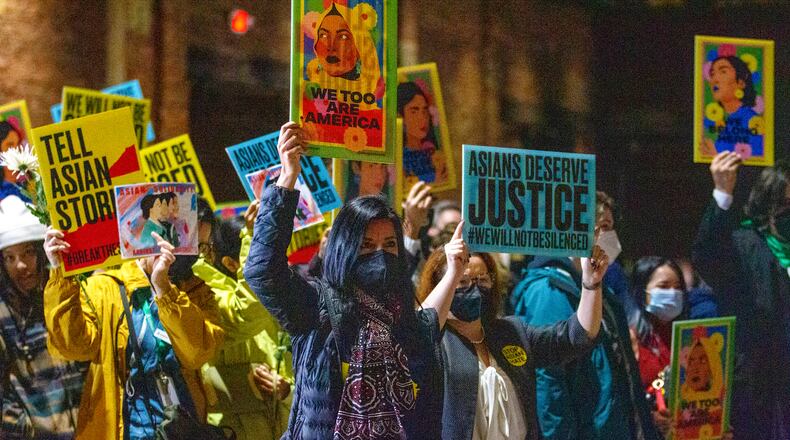 Participants at the Georgia Freight Depot wave signs at the beginning of the Asian Justice 1-year anniversary of the spa shootings rally in Atlanta on March 16, 2022. STEVE SCHAEFER FOR THE ATLANTA JOURNAL-CONSTITUTION