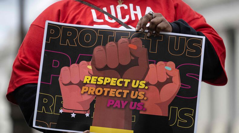 A person holds a sign as US Senator and Health, Education, Labor and Pensions Chairman Bernie Sanders (I-VT), not pictured, speaks during a news conference with labor leaders to make an announcement on the federal minimum wage, on Capitol Hill in Washington, D.C., on May 4, 2023. (Jim Watson/AFP/Getty Images/TNS)