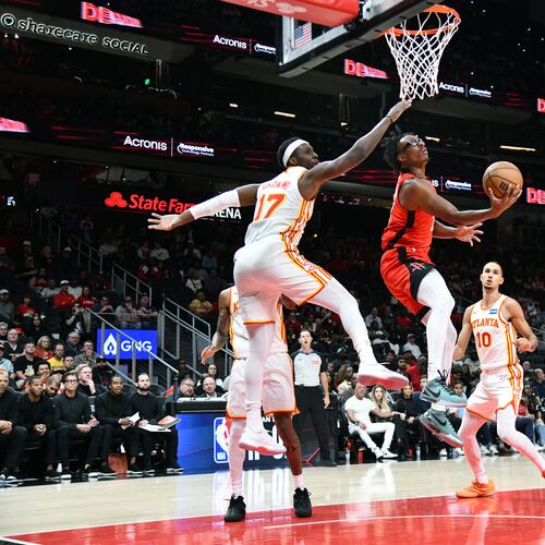 Houston Rockets forward Isaiah Crawford (center) goes to the basket for the shot against Atlanta Hawks forward/center Onyeka Okongwu (left) during the first half in a preseason NBA basketball game at State Farm Arena, Thursday, Oct. 16, 2025, in Atlanta. (Hyosub Shin/AJC)