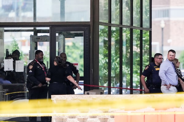 Law enforcement officers investigate the scene where a Harris County deputy and a suspect were shot outside the Family Law Center in Houston, Monday, April 21, 2025. (Brett Coomer/Houston Chronicle via AP)