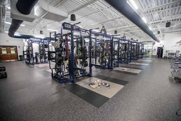 The weight room in the Thomas County Central indoor athletic facility features the Yellow Jacket mascot and other TCC logos throughout. (A. Wallace for the AJC)