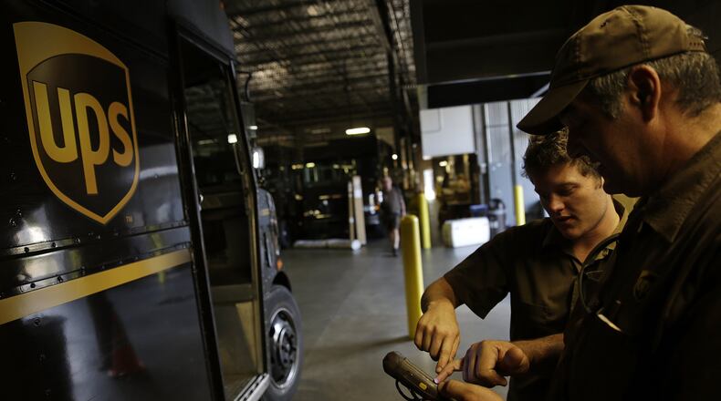 United Parcel Service driver Richard Trzcinski, right, goes over ORION, the automated computer system that devises optimal routes for its drivers, with fellow driver Daniel Petranck. A UPS facility in South Fulton was one of 56 projects that received property tax abatements. (AP Photo/David Goldman)