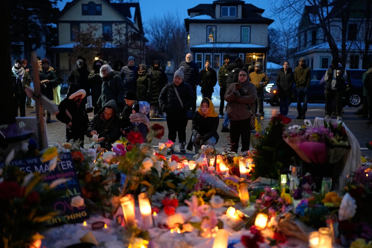People gather around a makeshift memorial honoring Renee Good in Minneapolis, Thursday, Jan. 8, 2026. Good was fatally shot by an ICE officer the day before. (John Locher/AP)