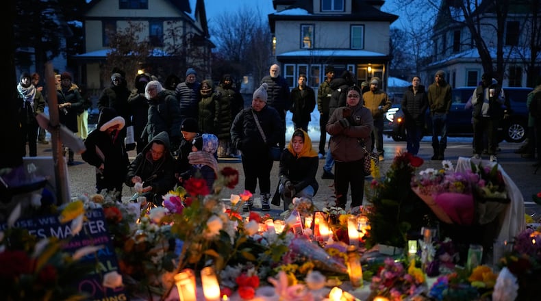 People gather around a makeshift memorial honoring Renee Good in Minneapolis, Thursday, Jan. 8, 2026. Good was fatally shot by an ICE officer the day before. (John Locher/AP)
