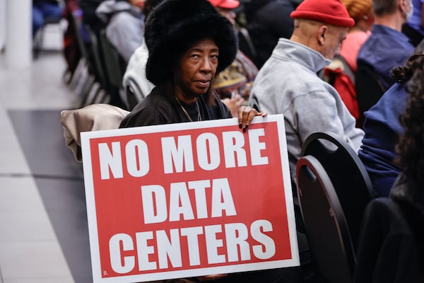 Ellenwood resident Sandra Holmes holds a sign during a town hall at the Porter Sanford III Performing Arts & Community Center in south DeKalb on Wednesday, Dec. 10, 2025. (Natrice Miller/AJC)
