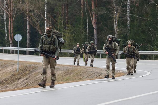 Lithuanian soldiers patrol on a road near a training range in Pabrade, north of the capital Vilnius, Lithuania on Thursday, March 27, 2025. (AP Photo/Mindaugas Kulbis)