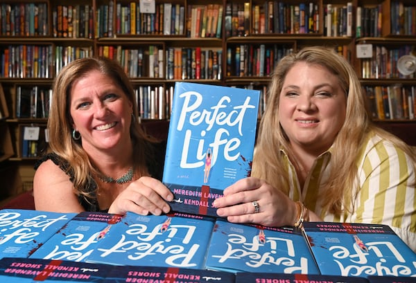 Meredith Lavender, left, and Kendall Shores, co-authors of Perfect Life, hold a copy of their book, Perfect Life, as they pose for a portrait at Eagle Eye Book Shop on Wednesday, July 8, 2026, in Decatur. (Hyosub Shin/AJC)