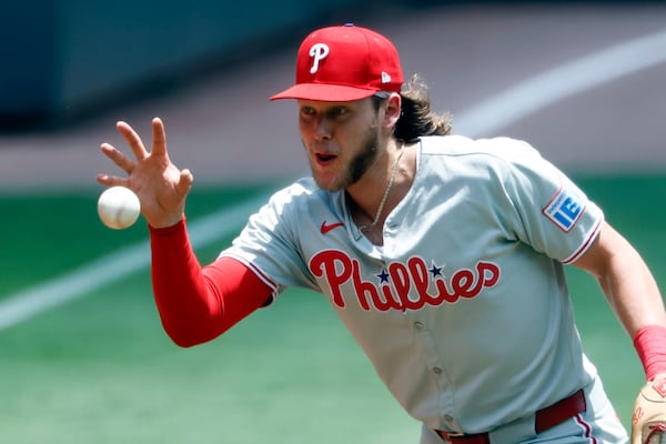 Philadelphia Phillies third baseman Alec Bohm fields a ground ball barehanded from Atlanta Braves' Matt Olson during the first inning of a baseball game, Sunday, June 29, 2025, in Atlanta. (AP Photo/Butch Dill)