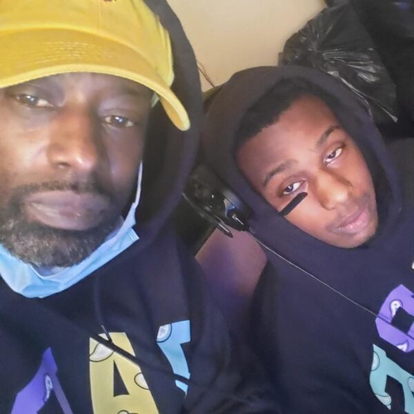 Damaje Favre (right) often visited his dad Davi Favre at his barber shop in Conyers. It has been hard on Davi to watch fathers and sons in his shop since Damaje was killed.