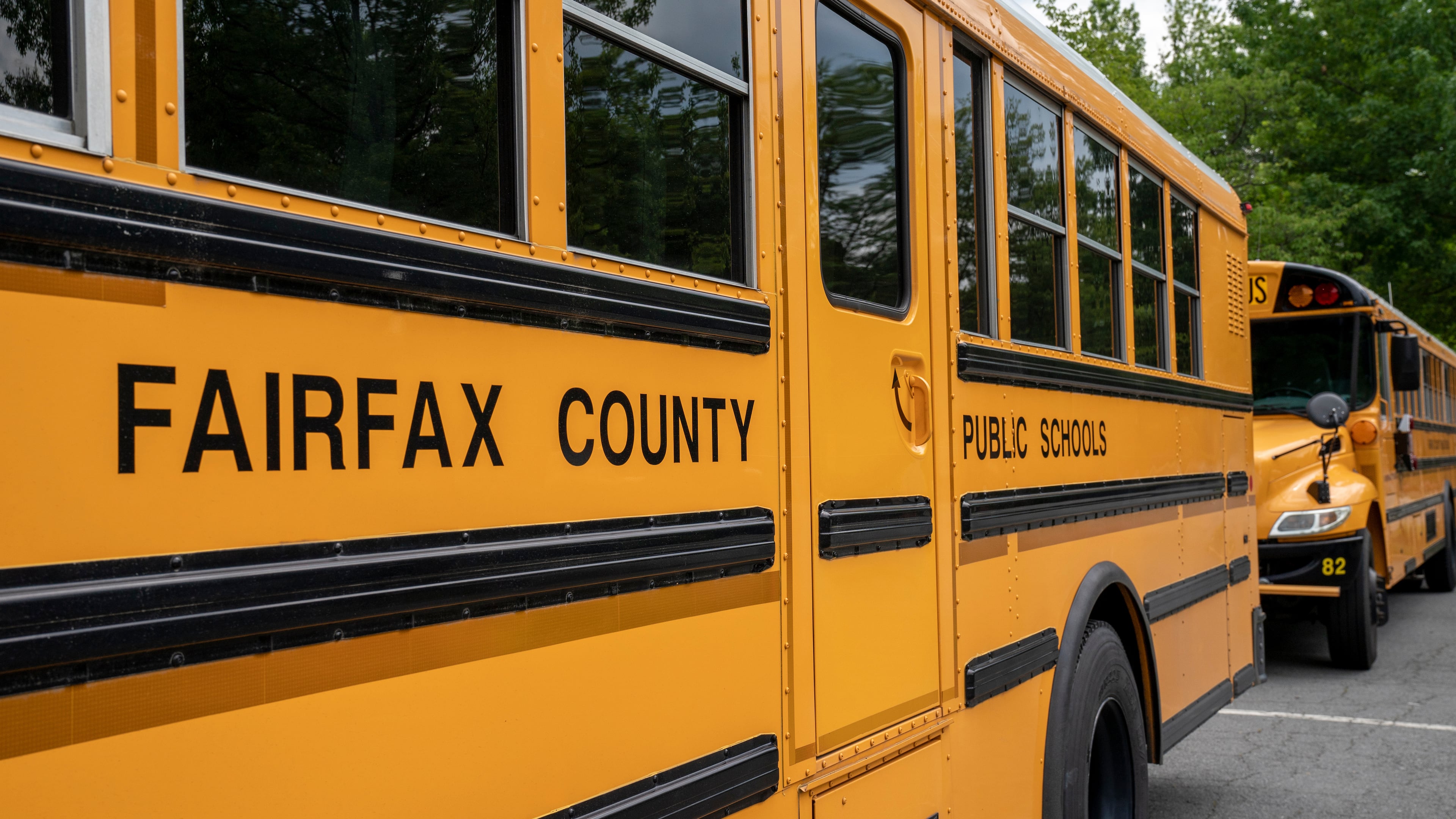 FILE - Fairfax County Public School buses idle at a middle school in Falls Church, Va., July 20, 2020. (AP Photo/J. Scott Applewhite, File)