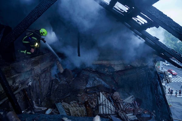 A rescue worker puts out a fire of a residential house heavily damaged by a Russian strike in Kyiv, Ukraine, on Thursday, July 10, 2025. (AP Photo/Evgeniy Maloletka)