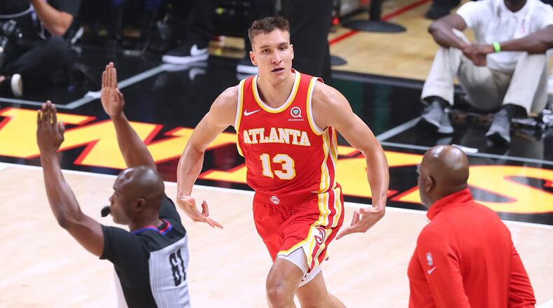 The Atlanta Hawks' Bogan Bogdanovic reacts to hitting a 3-pointer against the Philadelphia 76ers with interim head coach Nate McMillan looking on in Game 3 of their Eastern Conference semifinal at State Farm Arena on Friday, June 11, 2021, in Atlanta. The Sixers won, 127-111, for a 2-1 series lead. (Curtis Compton/Atlanta Journal-Constitution)