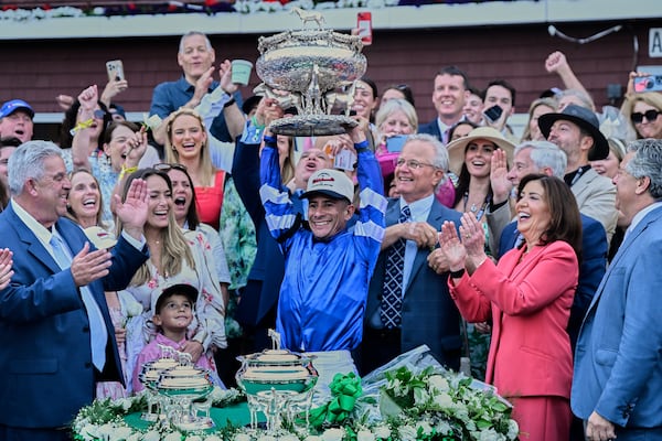 Jockey Junior Alvarado, center, holds up the August Belmont trophy after winning the 157th running of the Belmont Stakes horse race aboard Sovereignty (2), Saturday, June 7, 2025, in Saratoga Springs, N.Y. (AP Photo/Jessica Hill)