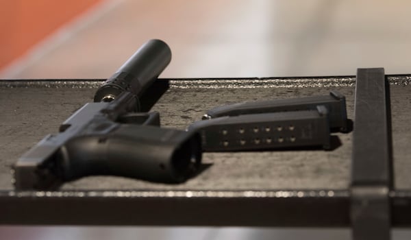 FILE - A handgun with a silencer and two magazines are shown at a gun range in Atlanta, Jan. 27, 2017. (AP Photo/Lisa Marie Pane, File)