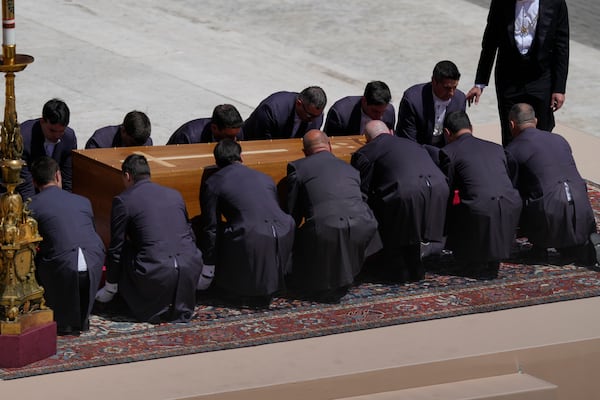 Pallbearers bend to lift the coffin of Pope Francis at the end of his funeral in St. Peter's Square at the Vatican, Saturday, April 26, 2025. (AP Photo/Gregorio Borgia)