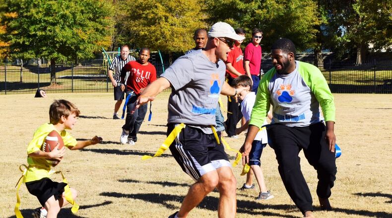Danny Wuerffel (center) plays flag football with kids in Atlanta. In college, Wuerffel won the Heisman Trophy as quarterback for the Gators. He went on to play for the New Orleans Saints and several other teams in the NFL. CONTRIBUTED