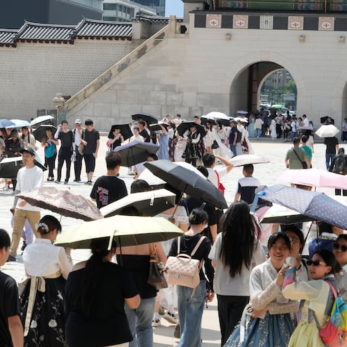 Visitors hold umbrellas to avoid sunshine at the Gyeongbok Palace in Seoul, South Korea, Wednesday, Aug. 5, 2026. (AP Photo/Ahn Young-joon)
