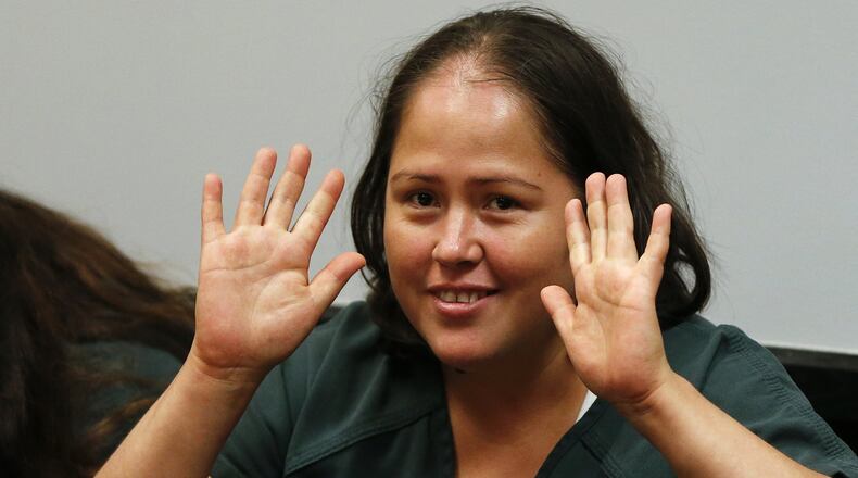 Isabel Martinez gestures towards news cameras during her first court appearance Friday, July 7, 2017, in Lawrenceville, Ga. Martinez is charged with killing four of her of children and their father. (AP Photo/John Bazemore)