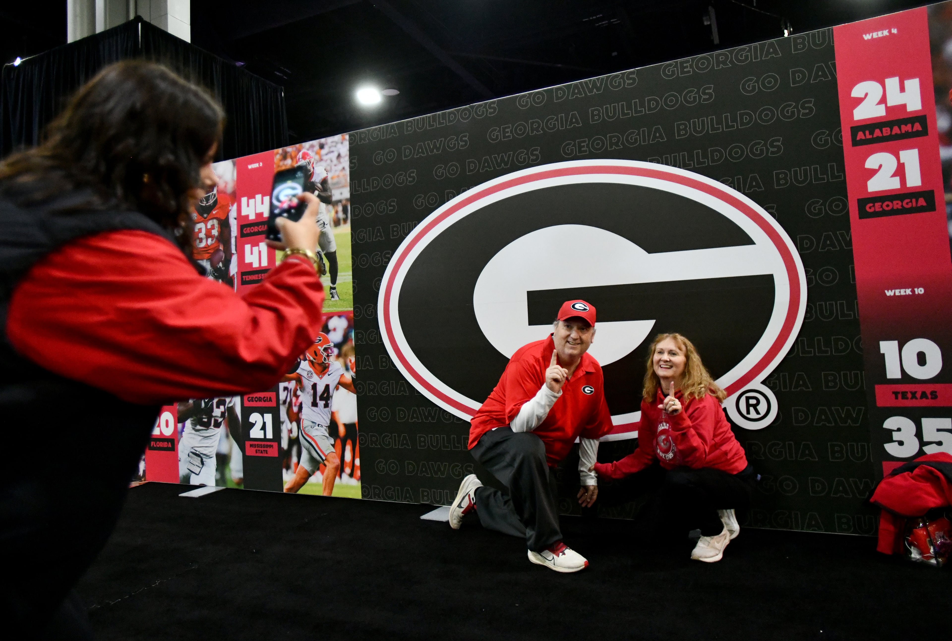 Georgia fans pose in front “G” sign at The Dr Pepper SEC FanFare ahead of the SEC Championship football game between Georgia and Alabama, Saturday, Dec. 6, 2025 in Atlanta. (Hyosub Shin/AJC)