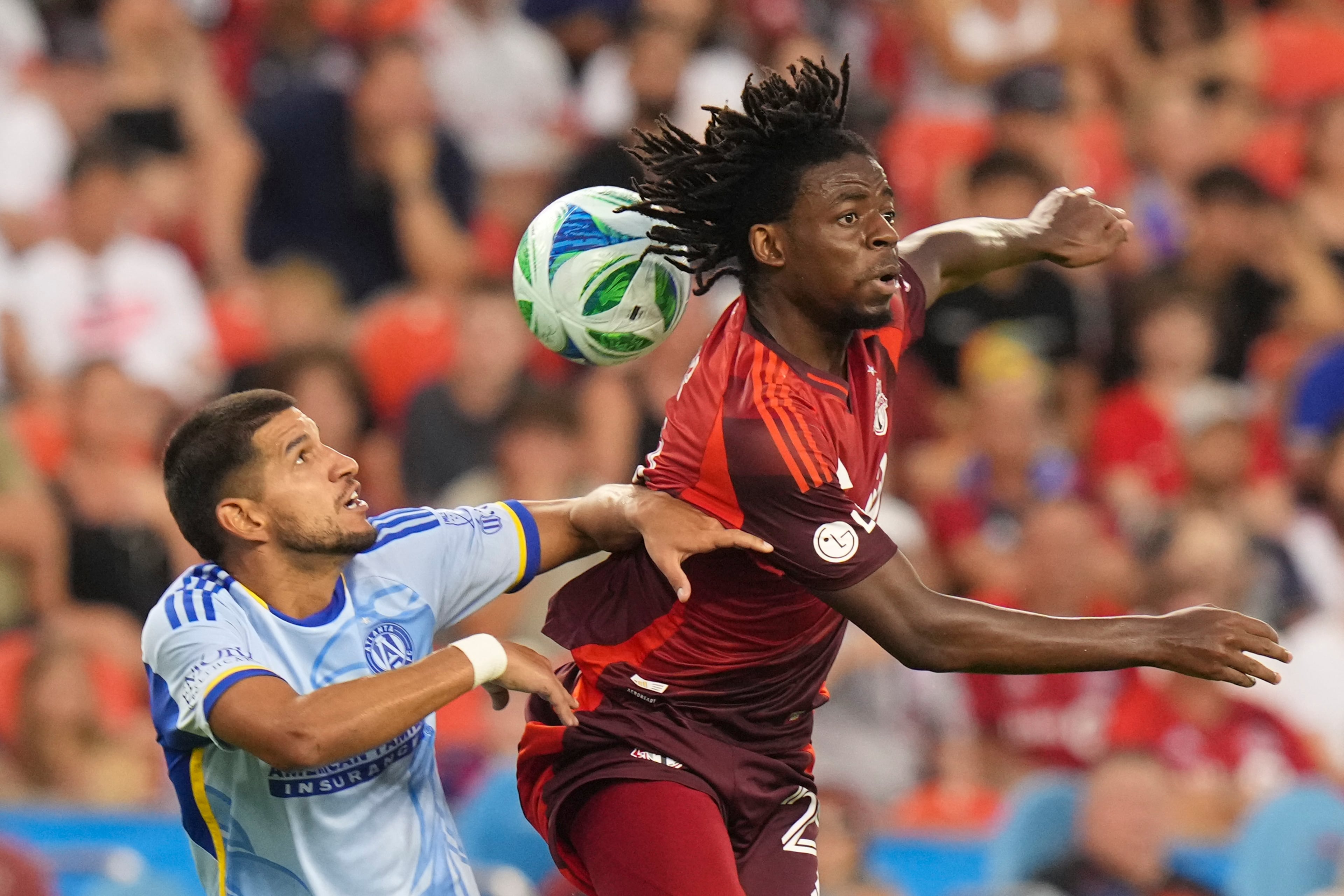 Toronto FC's Deandre Kerr, right, competes for the ball with Atlanta United's Luis Abram, left, during second-half MLS soccer match action in Toronto, Saturday, July 12, 2025. (Chris Young/The Canadian Press via AP)