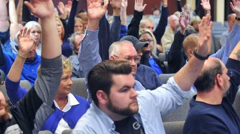 Those opposed to a rezoning request by Straight Street Revolution Ministries raised their hands Monday. (Credit: The Gainesville Times)