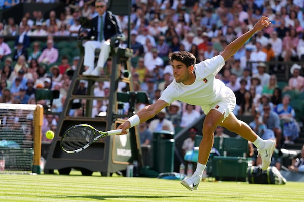 Carlos Alcaraz of Spain returns the ball to Oliver Tarvet of Britain in his second round men's singles match at the Wimbledon Tennis Championships in London, Wednesday, July 2, 2025.(AP Photo/Kirsty Wigglesworth)