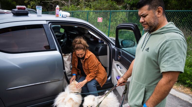 People tend to their pets outside Freedom Hall, an evacuation center in Fountain Valley, Calif., on Monday, May 25, 2026. (AP Photo/Ethan Swope)
