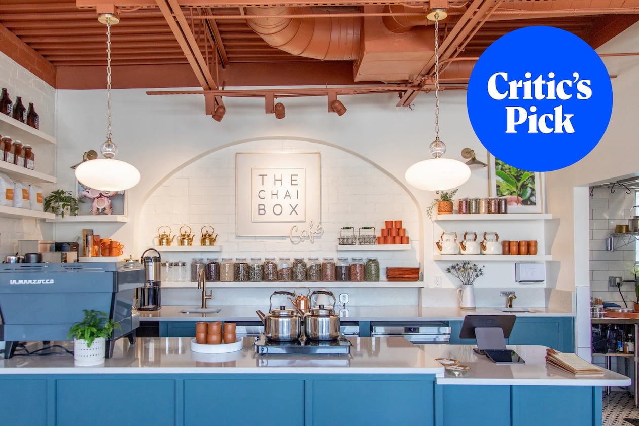The interior of a light, modern tea shop with an espresso machine and jars of tea