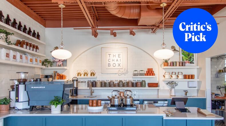 The interior of a light, modern tea shop with an espresso machine and jars of tea